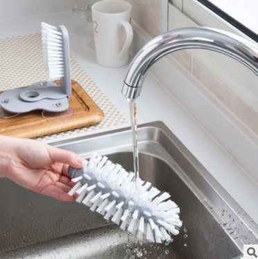 A gray suction cup brush for the kitchen, measuring approximately 17.5 by 14 centimeters. Made from PP+PVC materials, featuring a double-head design for effective cleaning