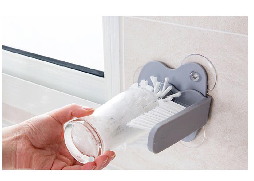 A gray suction cup brush for the kitchen, measuring approximately 17.5 by 14 centimeters. Made from PP+PVC materials, featuring a double-head design for effective cleaning